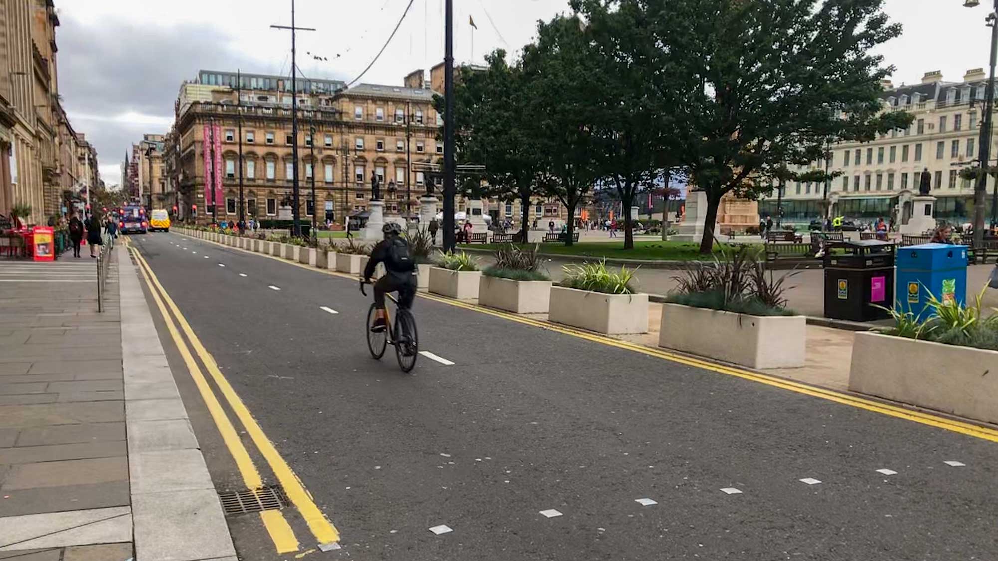 George Square, Glasgow with planter boxes and someone cycling on road